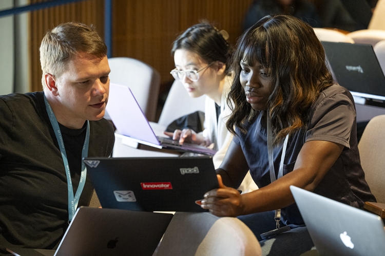 A caucasian man, a black woman, and an asian woman discuss computing topics.