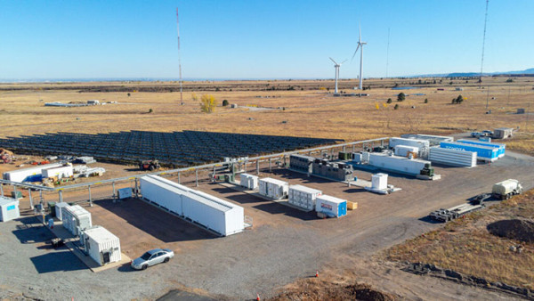 wind turbines, solar panels and energy storage facilities in a field