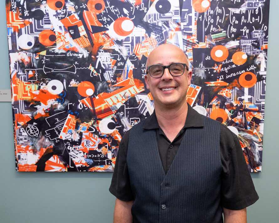 Visual artist Benjamin Arizmendi poses in front of his quantum-inspired artwork. (Credit: Paul Mueller/Berkeley Lab)