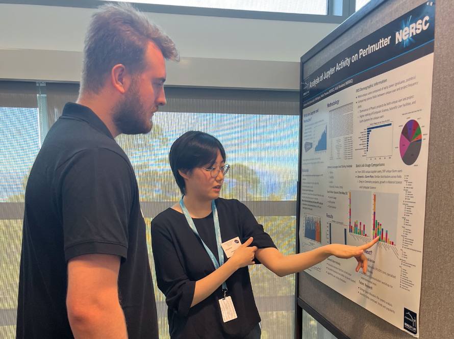 Two summer student program participants discuss a poster.