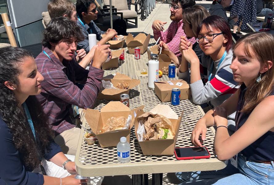 A diverse group of young people enjoy boxed lunches outdoors at Berkeley Lab.