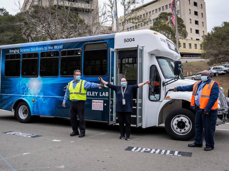 Berkeley Lab shuttle bus with three employees wearing safety vests.