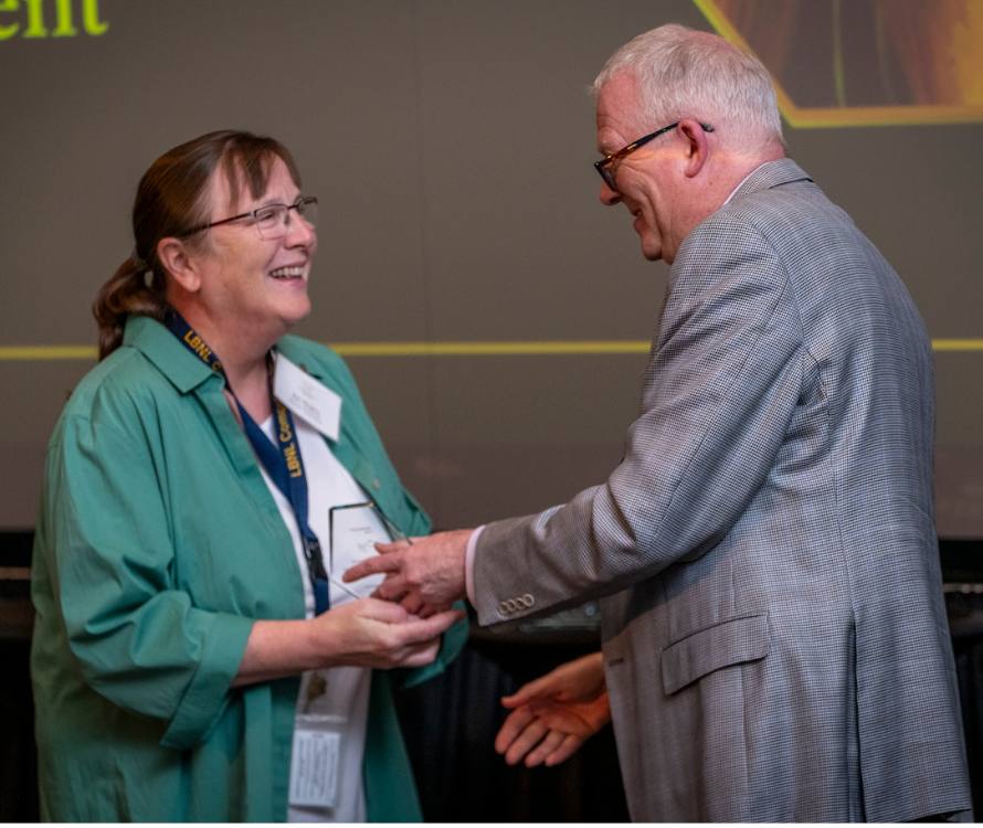 Ann Almgren receives a Director's Award from Jonathan Carter.