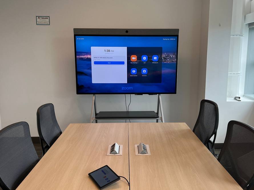 Sample Wang Hall AV set up featuring a large monitor with Neat camera and sound bar and iPad connectivity for Zoom meetings.