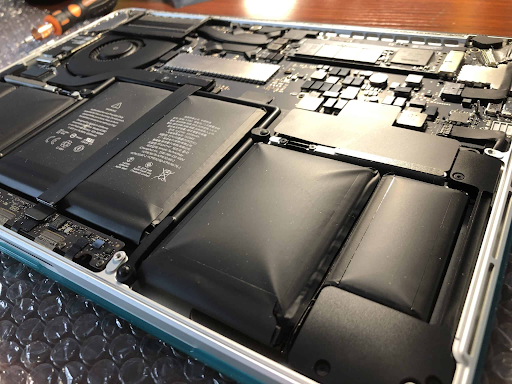 A photo of the inner workings of a typical laptop computer shows a risky, swollen battery that needs attention.