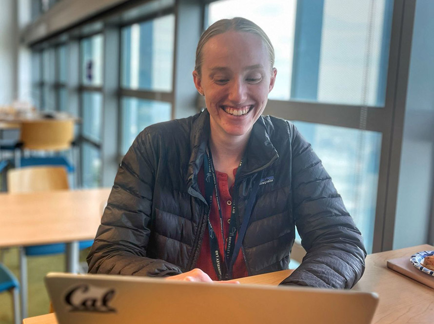 A scientist at a laptop in a break room space of Shyh Wang Hall during the AI Jam event.