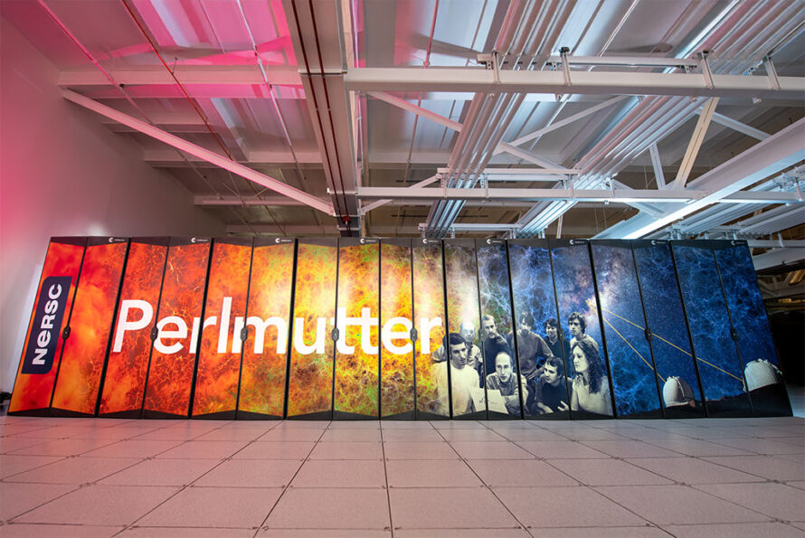 The Perlmutter supercomputer at NERSC, housed in a large facility with exposed ceiling pipes. Its cabinet panels feature a vibrant design with cosmic imagery, including orange and blue nebulae, a historical photo of physicist Saul Perlmutter with his research team, and an illustration of telescopes. The word 'Perlmutter' is prominently displayed across the panels.