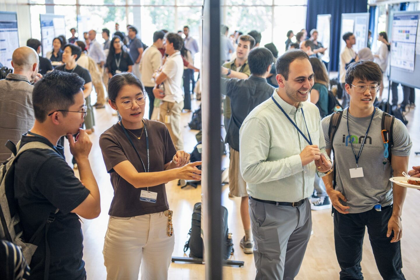 Two pairs of researchers discuss their work at a poster session