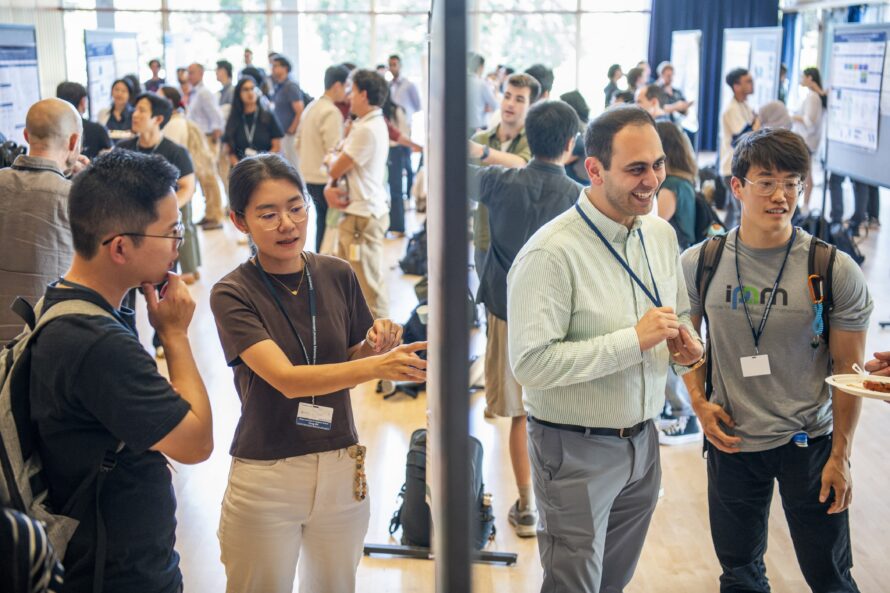 Two pairs of researchers discuss their work at a poster session